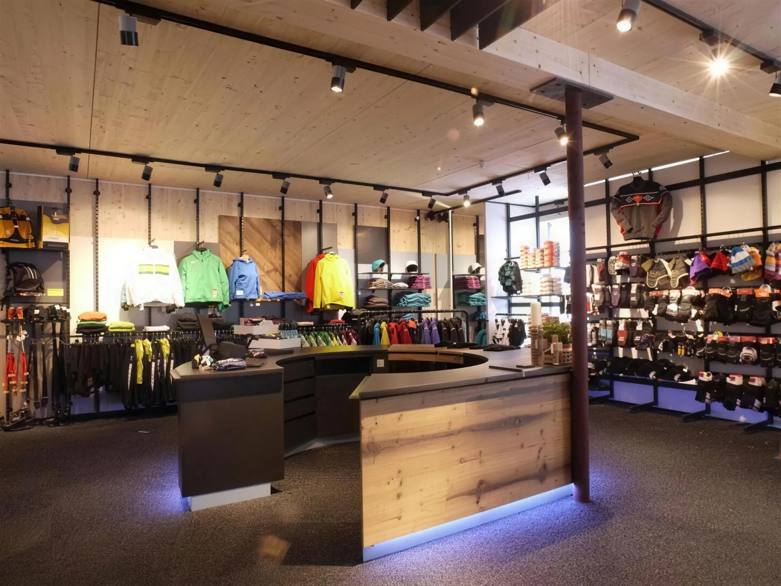 Verkaufsraum von Sport Strobl in Holzgau mit Holztresen und Skibekleidung